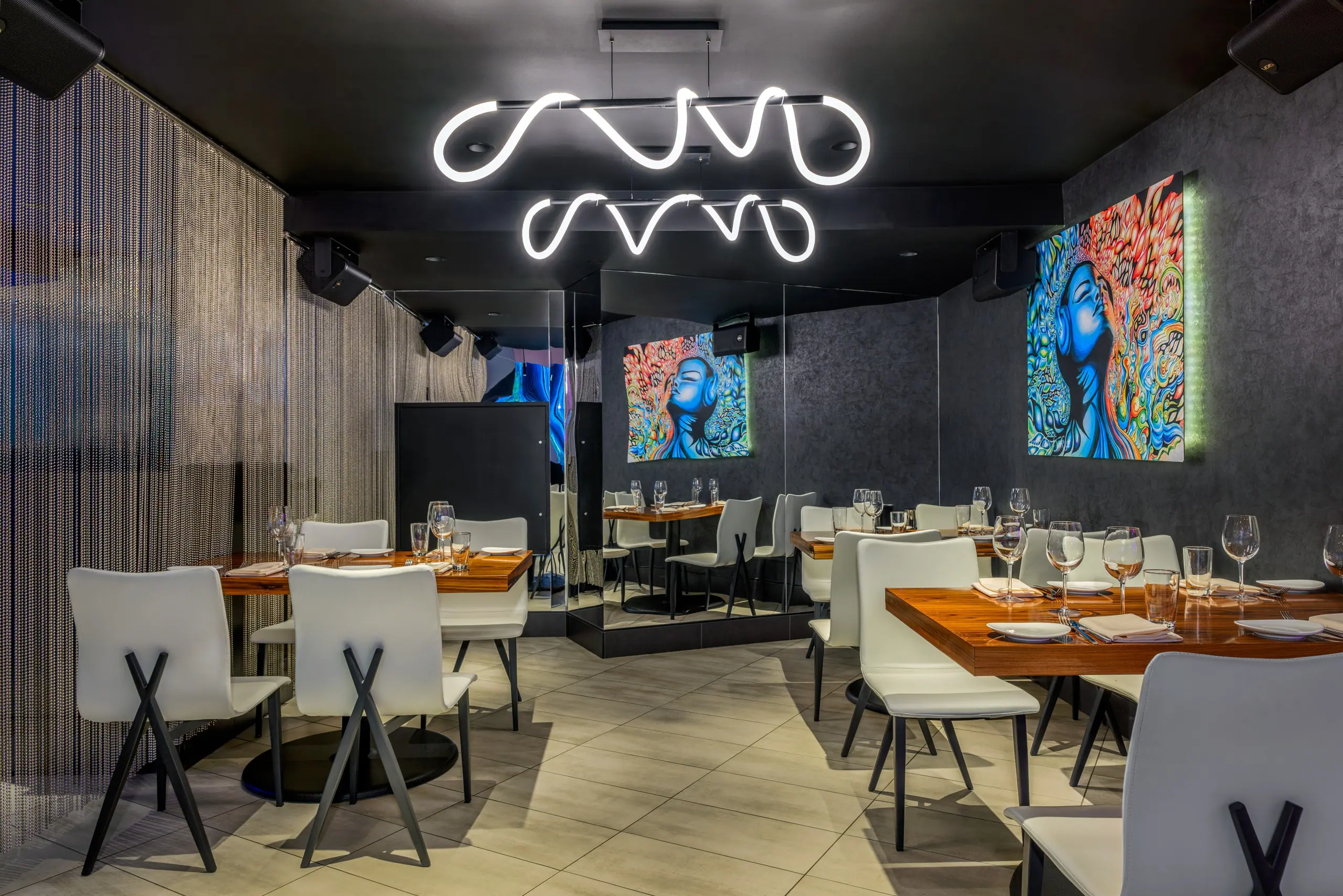 STK-Washington DC restaurant area, complete with laid tables and psychedelic artwork on the walls