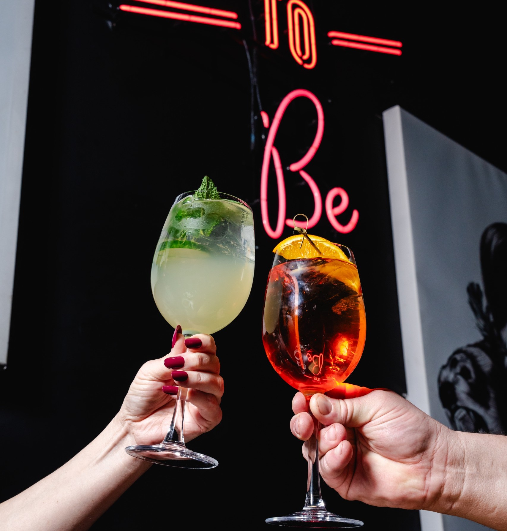 Two people clinking glasses of drinks together